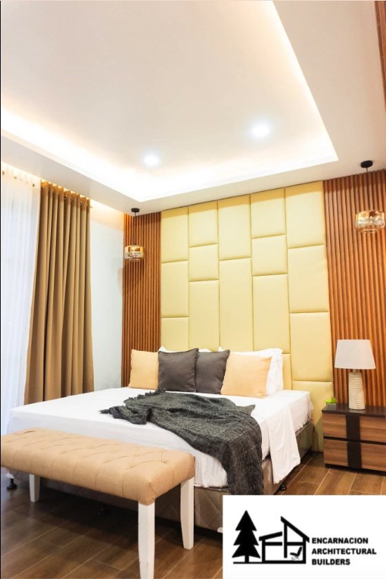 Finished guest bedroom with a panelled headboard and a recessed cove ceiling