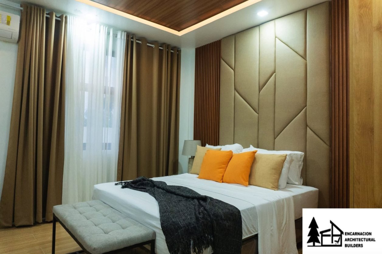 Bedroom with a padded headboard wall, timber slat detailing and a wood lined cove ceiling