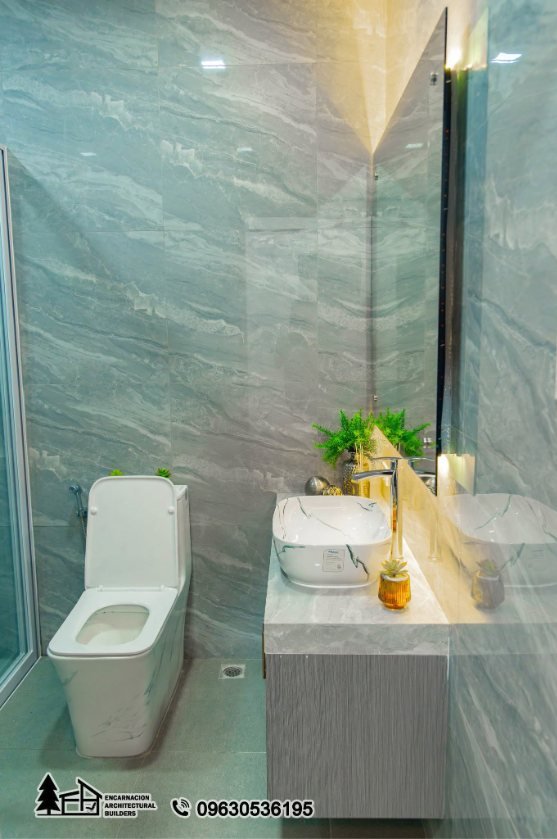 Powder room clad in veined stone tile with a vessel basin and a backlit mirror