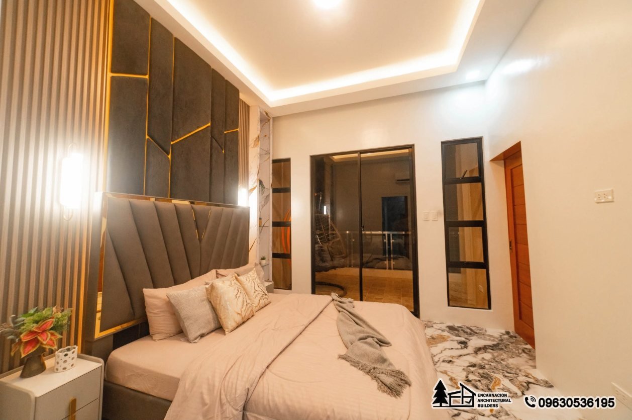 Primary bedroom with an upholstered feature wall and gold reveal lines