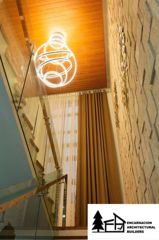 Timber lined ceiling above a stair void with a sculptural ring pendant